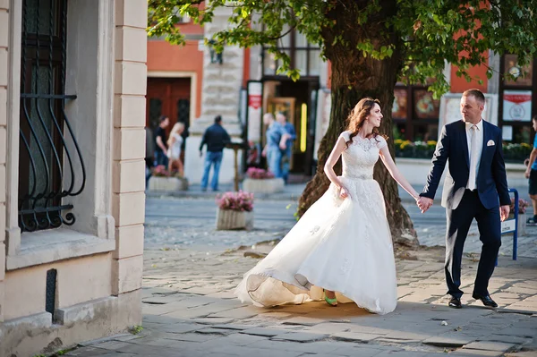 Newlyweds walking from streets of town — Stock Photo, Image