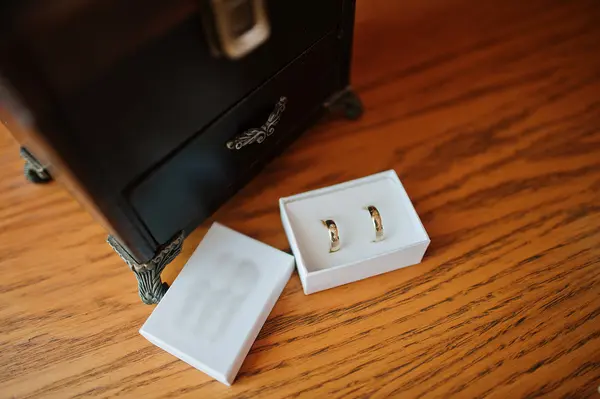 Two wedlock gold rings on white box background wooden table — Stock Photo, Image