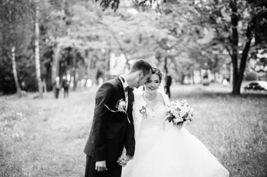 Genç güzel ve parkta yürüyüş çarklı Düğün çifti