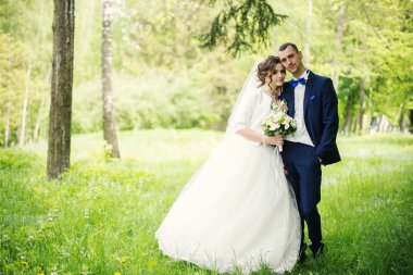 Genç güzel ve parkta yürüyüş çarklı Düğün çifti