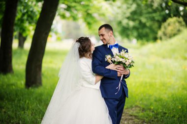 Genç güzel ve parkta yürüyüş çarklı Düğün çifti