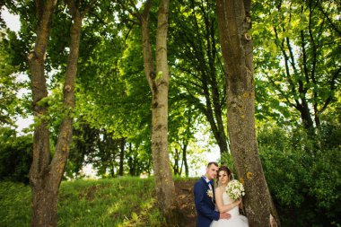 Genç güzel ve parkta yürüyüş çarklı Düğün çifti