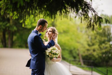 Genç güzel ve parkta yürüyüş çarklı Düğün çifti