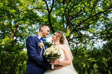 Genç güzel ve parkta yürüyüş çarklı Düğün çifti