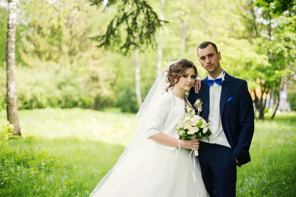 Jonge mooie en vrolijke bruidspaar, wandelen in het park — Stockfoto