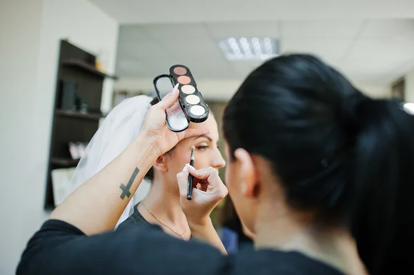 Maquillaje artista haciendo maquillaje para joven hermosa novia morena — Foto de Stock