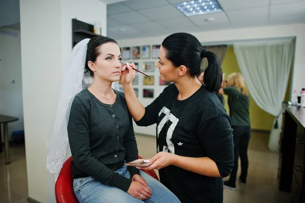 Maquillaje artista haciendo maquillaje para joven hermosa novia morena — Foto de Stock