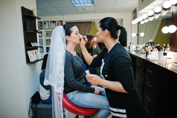 Maquillaje artista haciendo maquillaje para joven hermosa novia morena —  Fotos de Stock