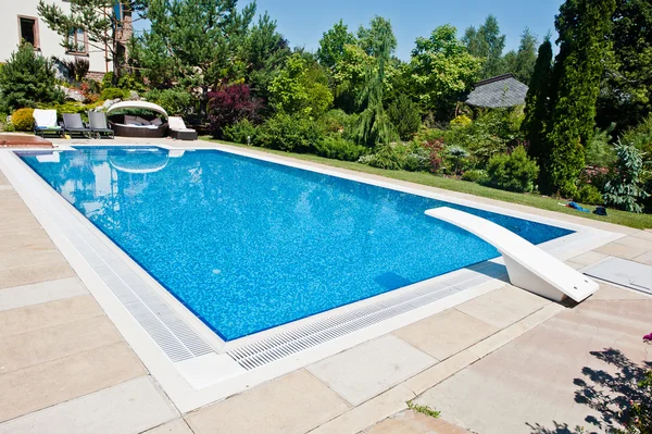 Piscina azul ao ar livre no dia ensolarado — Fotografia de Stock