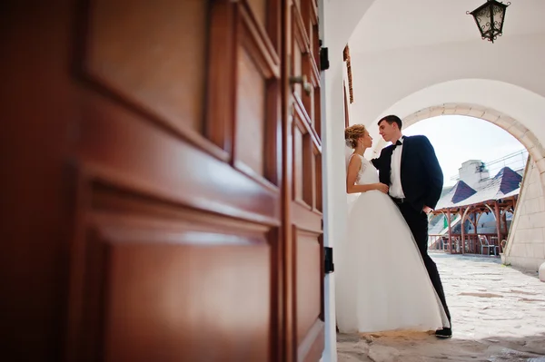 Recém-casados perto de portas de madeira — Fotografia de Stock