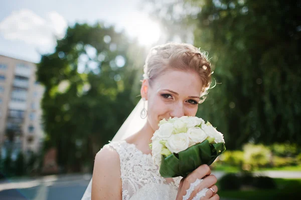 Blonde Braut schnüffelt Brautstrauß — Stockfoto