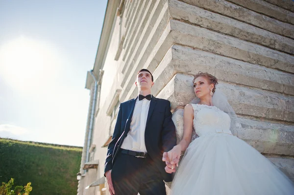 Wedding couple at the corner of the wall — Stock Photo, Image