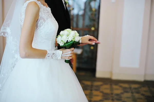 Handen van bruidspaar met boeket op ceremonie van het huwelijk — Stockfoto