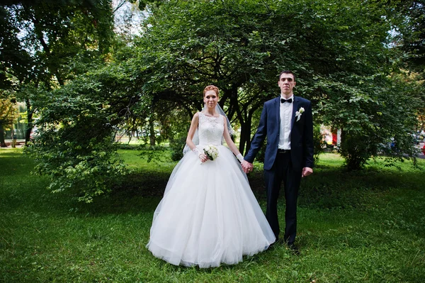 Exciting elegant wedding couple walking at park in love — Stock Photo, Image