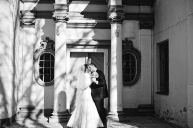 Muhteşem evli çift arka plan eski shad sütunlarla öpüşme