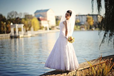 Genç esmer gelin buketi elinde ile arka plan Gölü poz verdi.