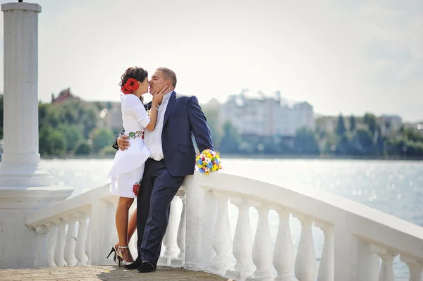 Pareja en vestido tradicional en el puente de piedra blanca cerca del lago —  Fotos de Stock