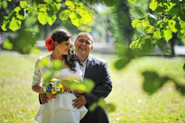 Par på traditionell klädsel bakgrund blad av träd — Stockfoto