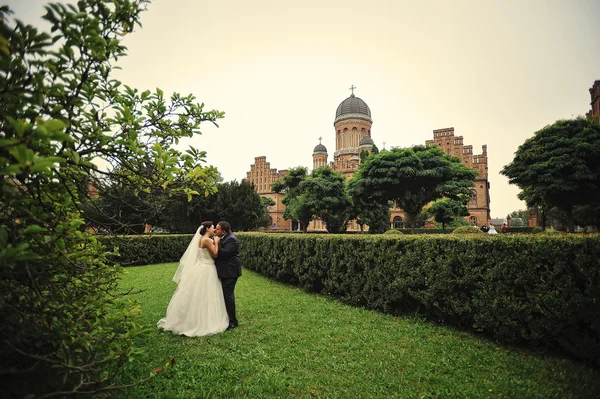 Recién casados fondo verde césped y antigua casa de arquitectura — Foto de Stock