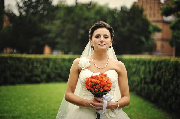 Брюнетка невеста со свадебным букетом под рукой — стоковое фото