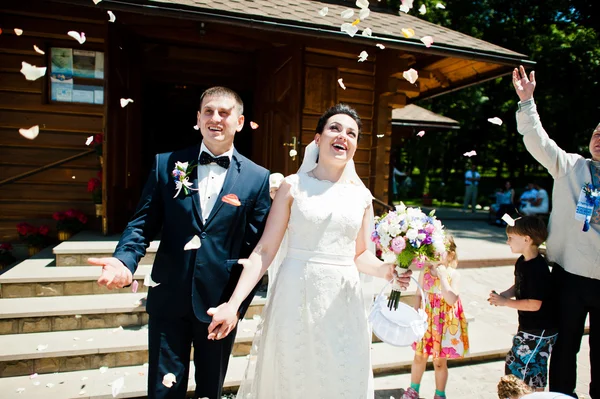 Лепестки роз в воздухе на свадебной паре — стоковое фото