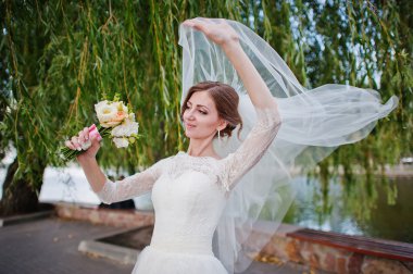 Nazik gelin peçe ve buket ile oynamak