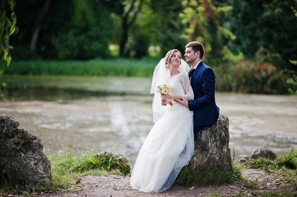 Svatební pár v parku poblíž dva kameny a jezero — Stock fotografie