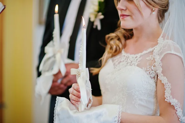 Noiva e noivo na igreja com vela à mão — Fotografia de Stock