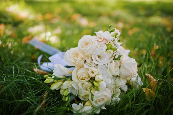 Bouquet de mariage avec bagues de fiançailles sur herbe verte — Photo