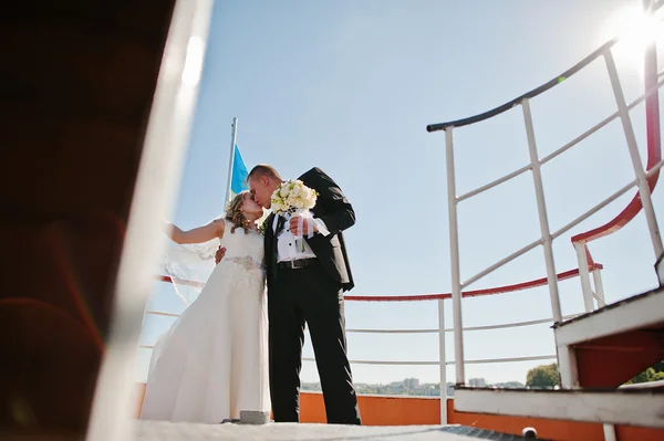 Bröllopsparet på fartyg med en liten båt — Stockfoto