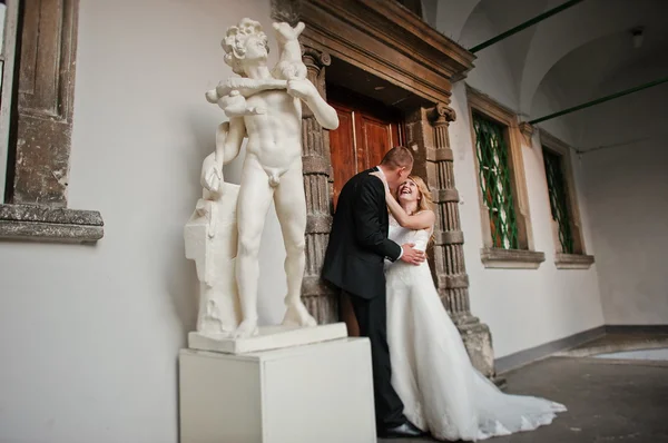 結婚式のカップルは、裸の男の像を背景します。 — ストック写真