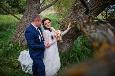 Evlilik çift yüksek çim ve ağaç yakınında