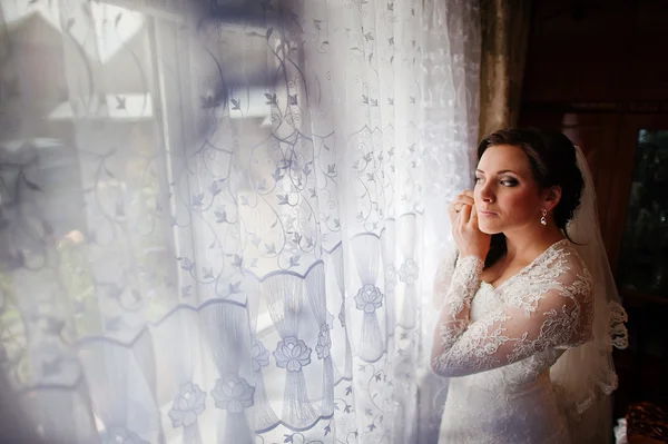 Bride wear earring near window — Stock Photo, Image