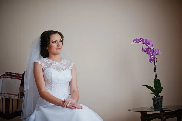 Vackra unga bruden bär mode klänning sitter på stol — Stockfoto