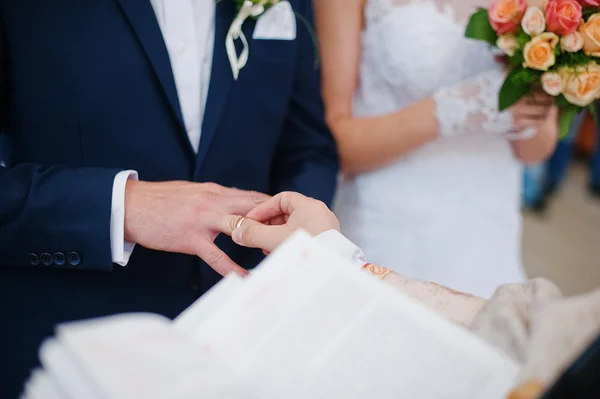 Priest wear ring on finger of groom — Stock Photo, Image