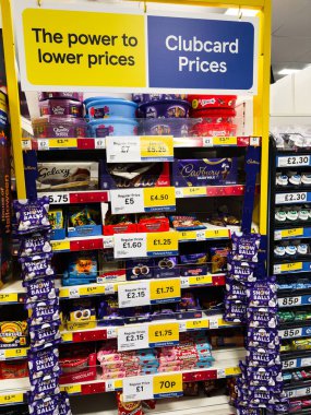 Manchester, İngiltere - 26 Eylül 2025: Bright Tesco mağazasının rafında Club card Fiyatları altında çikolata ve şeker indirimleri yer alıyor.