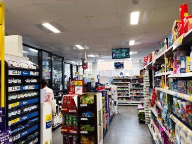 Manchester, İngiltere - 26 Eylül 2025: Kalabalık raflar ve işlek pazar ortamında çeşitli ürünlerle Bright Tesco mağaza sahnesi. 