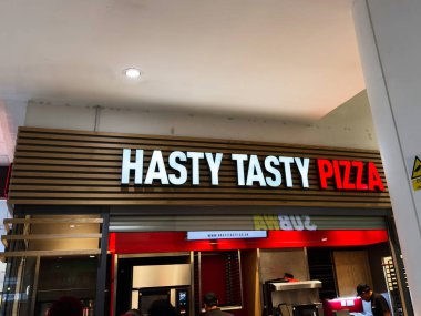 Manchester, İngiltere - 26 Eylül 2025: Ilık ahşap paneller ve çağdaş ışıklandırma ile bir alışveriş merkezinde Hasty Tasty Pizza okunuyor.