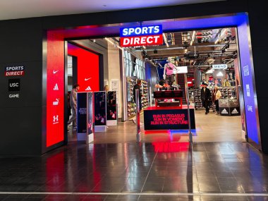 Manchester, İngiltere - 26 Eylül 2025: Modern bir spor mağazasının içinde renkli tabelalar, mankenler ve ayakkabı gösterileri müşterileri çekiyor.