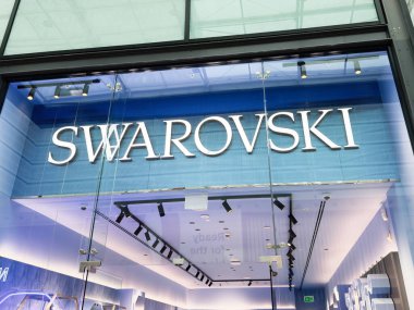 Manchester, İngiltere - 26 Eylül 2025: Mavi iç aydınlatma ve cam üzerinde büyük harflerle lüks marka mağazası.