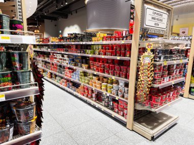 Manchester, İngiltere - 26 Eylül 2025: Meşgul bir Oseyo mağazası koridoru renkli hazır şehriyeler ve raflarda düzgünce dizilmiş ramen bardakları