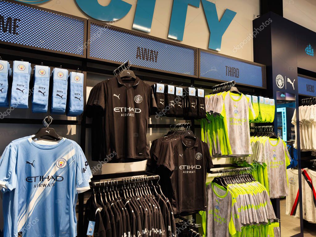 Manchester, UK - September 26, 2025: Man City retail display of blue and neon team jerseys, socks, and shirts in a sports shop.