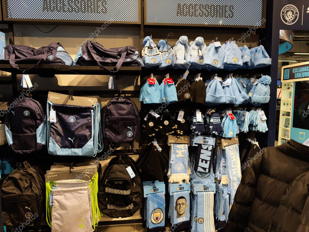 Manchester, UK - September 26, 2025: A Manchester City themed shop display with blue bags scarves hats gloves and winter gear.