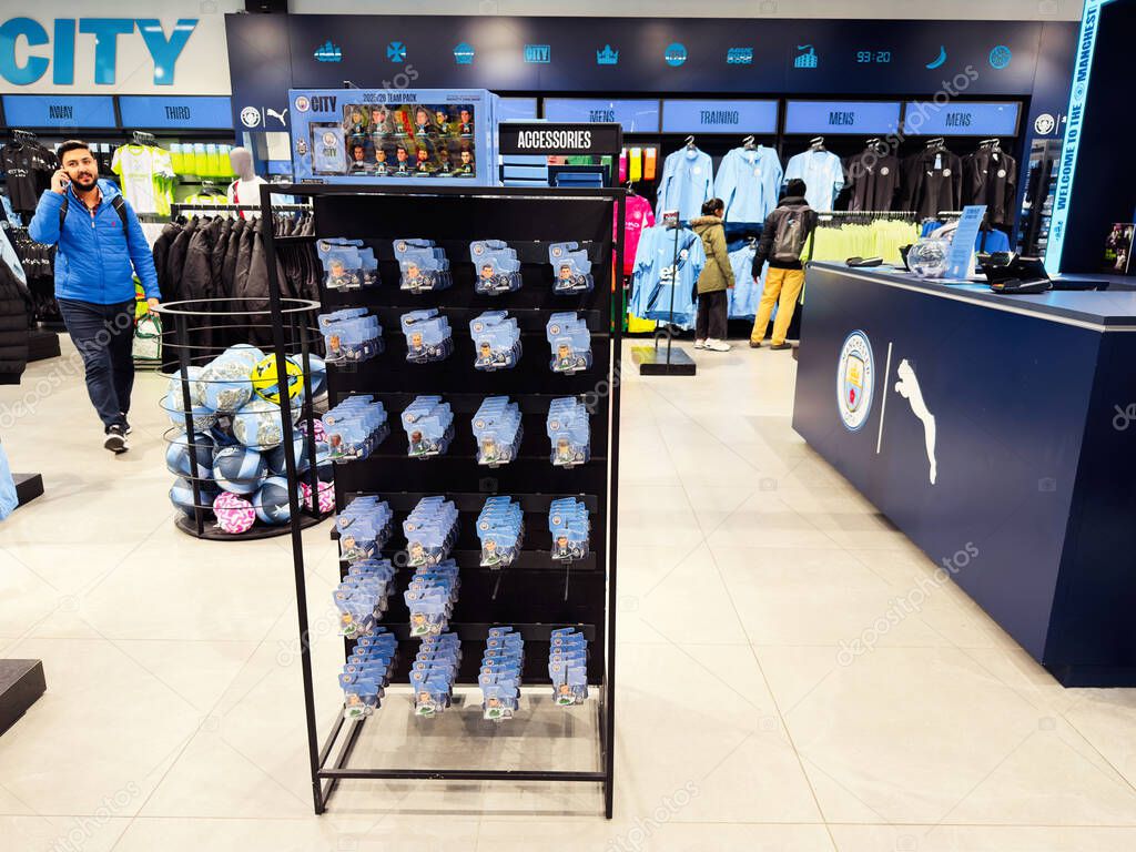 Manchester, UK - September 26, 2025: Modern Man City store interior featuring clothing displays, shoppers and bright lighting in a sportswear retail environment.