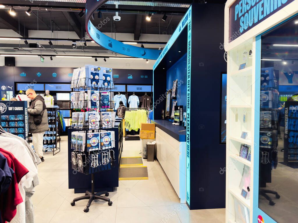 Manchester, UK - September 26, 2025: Busy retail Man City store with clothing racks, display stands, and a blue themed service counter.