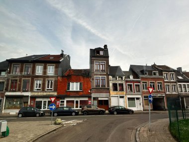 Liege, Belçika - 20 Ekim 2023: Liege, Belçika 'da kaldırım boyunca arabaları ve açık gökyüzü ve şehir atmosferi olan tuğlalı kasaba evleri.