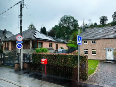 Liege, Belçika - 20 Ekim 2023: Geçiş işareti, yeşillik ve yağmurdan sonra ıslak kaldırım içeren sessiz Belçika konutları.