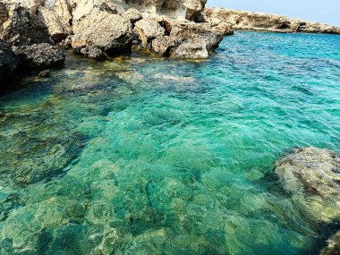 Paralimni, Kıbrıs - 18 Temmuz 2024: Kıbrıs Rum Kesimi 'nde şeffaf mavi deniz ve kayalık kıyıları olan el değmemiş kıyı şeridi.