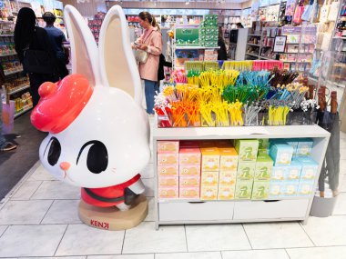 Manchester, İngiltere - 26 Eylül 2025: Meşgul bir Kenji dükkanında canlı bir kalem ve kırtasiye vitrininin yanında eğlenceli bir tavşan heykeli.