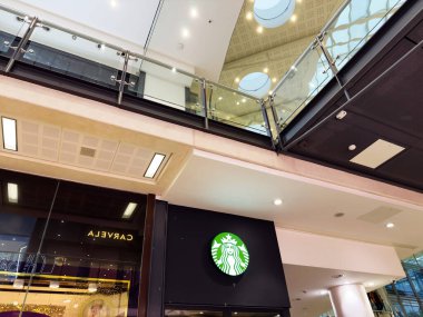Manchester, İngiltere - 26 Eylül 2025: Starbucks kafe ve cam balkonun yer aldığı parlak alışveriş merkezi içi.